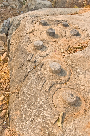 Carved Shiva lingams on rock surfaces - Click to show bigger image in new browser