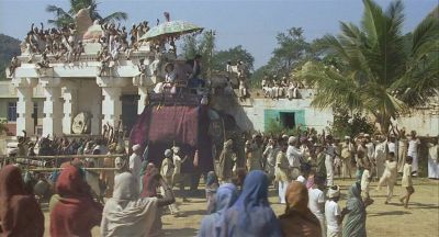 The elephant sets off through the village - Click to show full-size image in new browser
